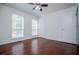 Bedroom is well-lit with hardwood floors, two windows, and a ceiling fan at 4066 Harvest Ridge Dr, Douglasville, GA 30135
