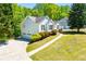 View of the home's side and garage entrance, complete with a well-kept lawn and blooming bushes at 4066 Harvest Ridge Dr, Douglasville, GA 30135