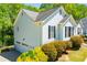 Side exterior view showcasing a white home with a three-car garage and well-maintained landscaping at 4066 Harvest Ridge Dr, Douglasville, GA 30135