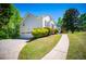 Exterior view of a white home featuring a long driveway, lush landscaping, and a well-manicured lawn at 4066 Harvest Ridge Dr, Douglasville, GA 30135