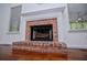 Close-up of the red brick fireplace with white mantel and hearth in the living room at 4066 Harvest Ridge Dr, Douglasville, GA 30135