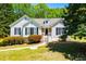 Charming one-story home featuring a well-maintained lawn, complemented by vibrant bushes and classic black shutters at 4066 Harvest Ridge Dr, Douglasville, GA 30135