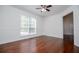 Bright living room featuring hardwood floors, a ceiling fan, and a large window for natural light at 4066 Harvest Ridge Dr, Douglasville, GA 30135