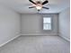 Large bedroom with neutral paint and carpet and large window at 5525 Nesmith Ct, Cumming, GA 30040