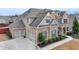 Beautiful brick home with a three-car garage and manicured landscaping at 5525 Nesmith Ct, Cumming, GA 30040