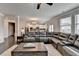 Bright living room with dark hardwood floors, a large sectional sofa and access to the open concept kitchen at 5525 Nesmith Ct, Cumming, GA 30040