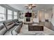 Inviting living room with a stone fireplace and built-in shelving, seamlessly connecting to an adjacent room at 5525 Nesmith Ct, Cumming, GA 30040