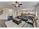 Open-concept living room with dark hardwood floors, a large sectional sofa, and seamless access to kitchen at 5525 Nesmith Ct, Cumming, GA 30040