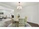 Cozy dining area with a modern chandelier, seating for four, and views into the living room at 151 John Christopher Dr, Alpharetta, GA 30009