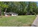 Large front yard with a cute white brick home surrounded by lush trees at 151 John Christopher Dr, Alpharetta, GA 30009