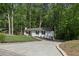 This home boasts a long driveway, pristine landscaping, and lush surrounding trees at 151 John Christopher Dr, Alpharetta, GA 30009