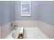 Soaking tub features modern fixtures, a white tile surround, and a wood bath caddy at 2630 Talley St # 319, Decatur, GA 30030