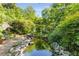 A tranquil backyard pond is surrounded by lush greenery and rock features at 374 8Th Ne St, Atlanta, GA 30309