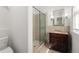 Modern bathroom featuring a walk-in shower, vanity with a dark wood cabinet, and natural stone tile at 374 8Th Ne St, Atlanta, GA 30309