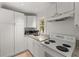 Compact kitchen with white cabinets, granite countertops, and modern appliances at 374 8Th Ne St, Atlanta, GA 30309
