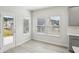 Bright dining area featuring large windows, modern floors, and backyard access at 7757 Sheffield Ter, Fairburn, GA 30213