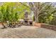 Picturesque backyard featuring stone fireplace and outdoor seating underneath mature trees at 3318 Monceau Way, Roswell, GA 30075
