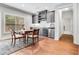 Basement wet bar with granite countertop, gray cabinets, and dining area by the window at 3318 Monceau Way, Roswell, GA 30075