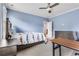 Light blue bedroom with a ceiling fan, bed with printed comforter, desk, and dresser at 3318 Monceau Way, Roswell, GA 30075