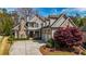 Stunning two-story home featuring a stone chimney, three-car garage, and beautifully landscaped front yard at 3318 Monceau Way, Roswell, GA 30075