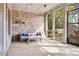 Enclosed outdoor patio with brick accent wall, ceiling fan, seating area, and backyard views at 3318 Monceau Way, Roswell, GA 30075