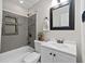 Bathroom featuring a bath tub with shower, gray tile, a vanity and black framed mirror at 3690 Asbury Sw Ln, Atlanta, GA 30331