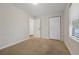 Carpeted bedroom includes a window, closet and an entry door at 3690 Asbury Sw Ln, Atlanta, GA 30331