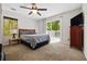 Well-lit bedroom with carpet, a side table lamp, and sliding glass doors to the deck at 3690 Asbury Sw Ln, Atlanta, GA 30331