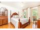 Bedroom with hardwood floors, a four poster bed, and a china cabinet at 4579 Blakedale Ne Cir, Roswell, GA 30075