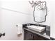 Elegant powder room featuring dark granite counters, white ceramic sink, and decorative mirror and lighting at 4579 Blakedale Ne Cir, Roswell, GA 30075