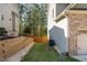 Backyard with grassy area, wooden retaining wall and privacy fence at 6424 Barker Station Walk, Sugar Hill, GA 30518