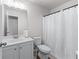 Bright bathroom with white vanity, toilet, and shower with white curtain at 6424 Barker Station Walk, Sugar Hill, GA 30518