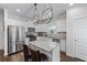 Bright kitchen boasts stainless appliances, granite countertops, white cabinets, and modern lighting fixtures at 6424 Barker Station Walk, Sugar Hill, GA 30518