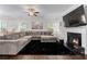 Spacious living room features a cozy fireplace, large sectional sofa, and ample natural light at 6424 Barker Station Walk, Sugar Hill, GA 30518