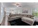 Open-concept living room with a large sectional sofa, adjacent to a modern kitchen, creating a great entertaining space at 6424 Barker Station Walk, Sugar Hill, GA 30518