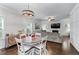 Cozy dining area next to living room includes a round table, stylish chandelier, and view of the fireplace at 6424 Barker Station Walk, Sugar Hill, GA 30518