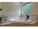 Bright bathroom featuring a corner tub with black faucet and neutral-toned tile surround and a stack of towels at 125 Mayo Rd, Covington, GA 30014