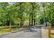 Scenic driveway leading to a home, framed by lush trees and a charming wooden fence, creating a welcoming entrance at 125 Mayo Rd, Covington, GA 30014