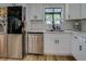 Close-up of the kitchen sink area, featuring stainless steel appliances and white cabinetry at 125 Mayo Rd, Covington, GA 30014
