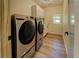 Laundry room featuring modern appliances, tile backsplash, and wood-style floors, seamlessly combining form and function at 125 Mayo Rd, Covington, GA 30014