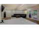 Spacious living area featuring hardwood floors, a leather sectional sofa, and access to an outdoor deck with scenic views at 125 Mayo Rd, Covington, GA 30014