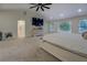 Bright carpeted main bedroom featuring a large ceiling fan, tv, and a walk-in closet at 125 Mayo Rd, Covington, GA 30014