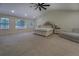 Spacious main bedroom featuring a tray ceiling, ceiling fan, large windows and plush carpet at 125 Mayo Rd, Covington, GA 30014