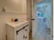 Charming powder room featuring shiplap, black fixtures, and neutral tile flooring leading into adjacent room at 125 Mayo Rd, Covington, GA 30014