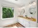 Bright bathroom with double sinks, butcher block counters, shiplap walls and a large window at 1605 Gilstrap Nw Ln, Atlanta, GA 30318