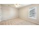 Bright, carpeted bedroom with a ceiling fan and view of the yard through the window at 1605 Gilstrap Nw Ln, Atlanta, GA 30318