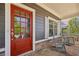 Cozy front porch with a red door, rocking chairs, and stone accents, creating a welcoming outdoor space at 1605 Gilstrap Nw Ln, Atlanta, GA 30318