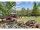A park scene with picnic tables, a gazebo, and a playground surrounded by mature trees and greenery at 1605 Gilstrap Nw Ln, Atlanta, GA 30318