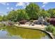 Scenic pond with wooden bridge, stone fireplace, and sitting area amidst lush surroundings at 1605 Gilstrap Nw Ln, Atlanta, GA 30318