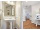 Charming powder room featuring a pedestal sink, wainscoting, and decorative mirror at 1605 Gilstrap Nw Ln, Atlanta, GA 30318